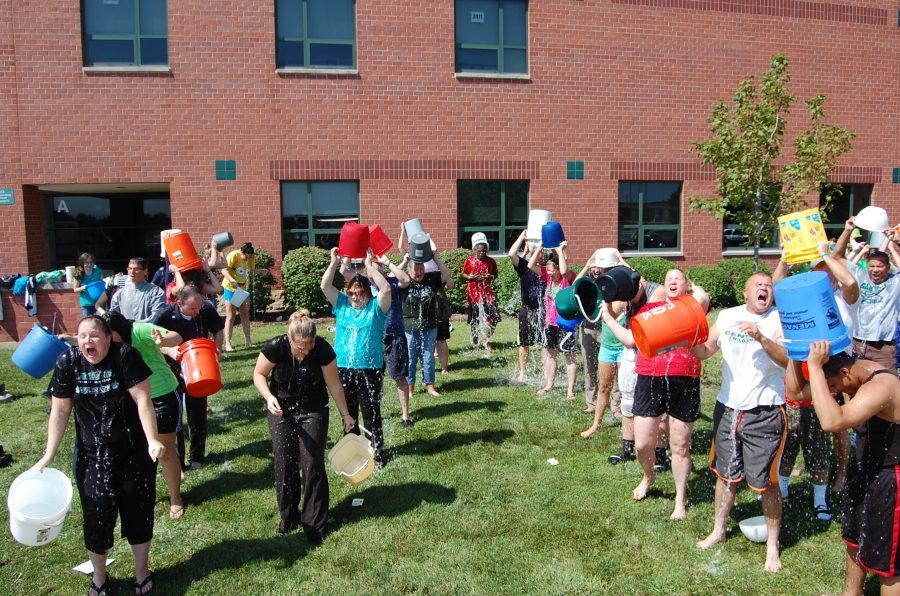 Staff members douse themselves outside of school to raise awareness and money for ALS research.