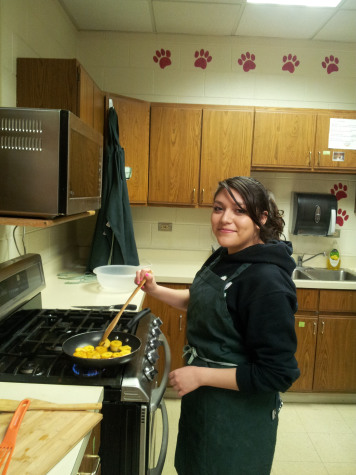 Junior Ana Maldonado making tostones, a traditional Latino food, as part of the Spanish club.