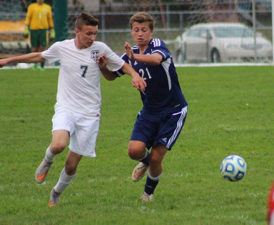 Junior Max Woodward wards off a defender to receive the ball  against Oswego East on Tuesday, Sept. 29.