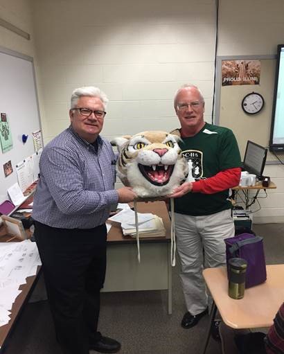 Dan Valkema, band director, passes the Wildcat head to Tom Bond, calculus teacher. 