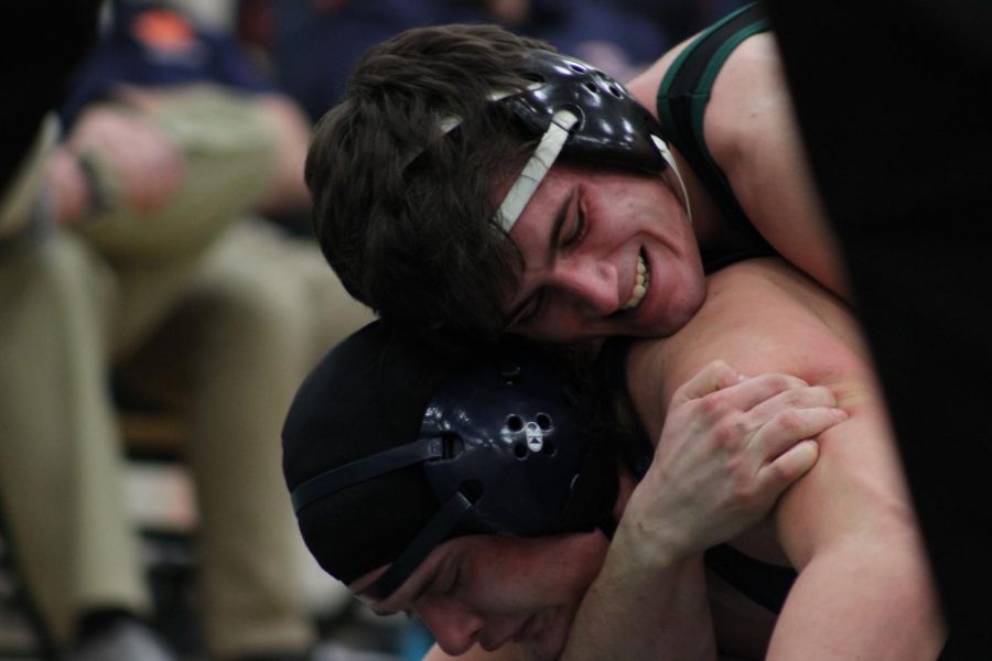 Senior Josh Makenzie attemps to take down his Oswego opponent on Wednesday, Feb. 24. 