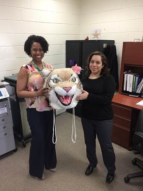 Xiomara Cole passes the Wildcat Head to Sarah Cammack in Student Services.