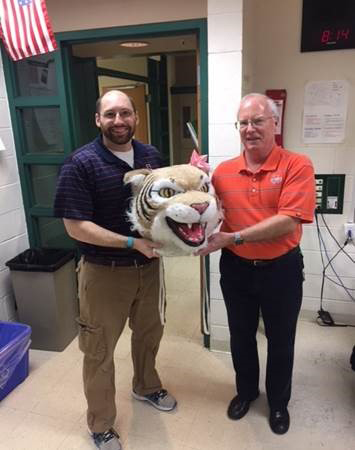 Tom Bond, math teacher, passes the Wildcat head to Ben Nugent, science teacher.