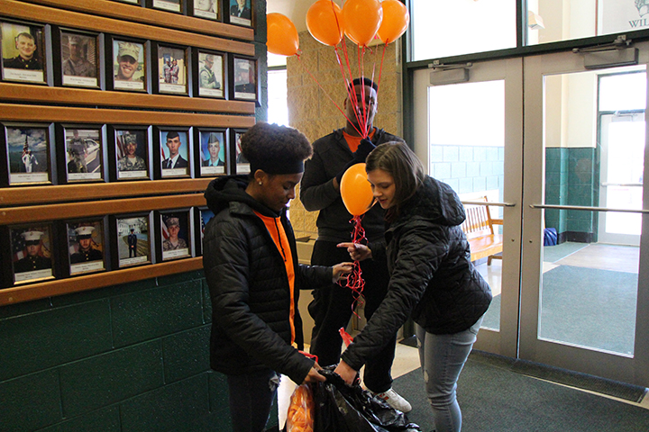 Seniors Jade Smith, Bradley Rucker, Emma Jaszczak prepare to bring out the balloons to be released. These three students were integral in organizing the event.