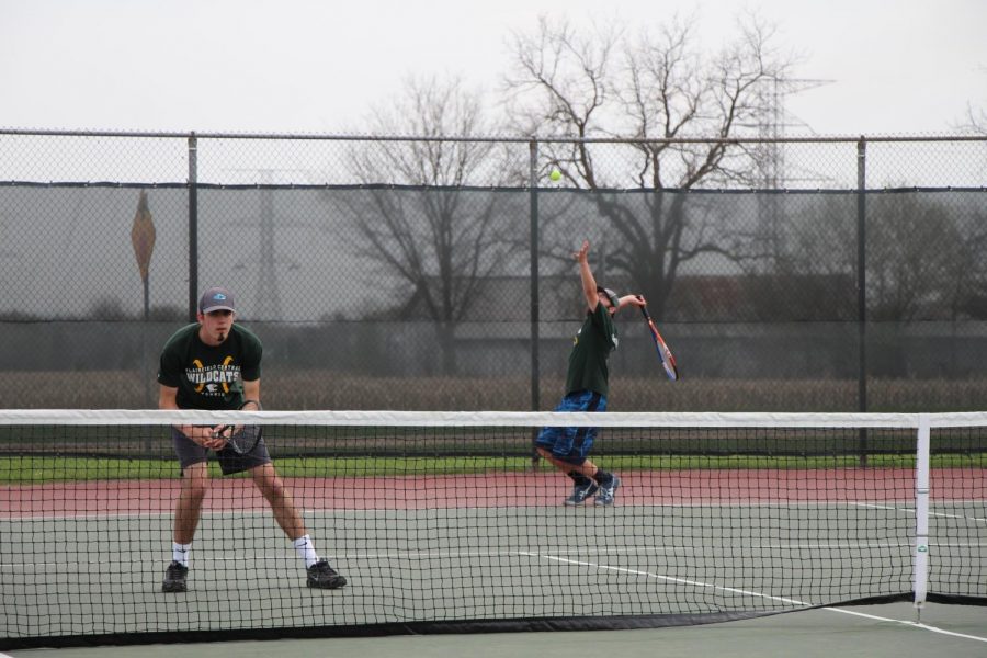 Senior Sam Jackson prepares for the return as his partner, senior Noah Bylon serves.