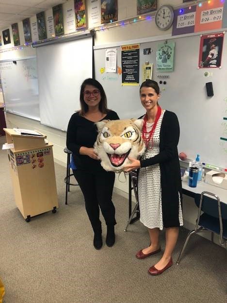 Ashley Krause, English teacher, passes the Wildcat Award to Kristine Murphy, SPED teacher.