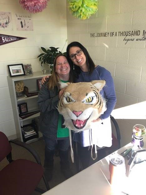 Special Education teacher Shana Shaver passes the Wildcat award to Julie Banholzer, counselor.