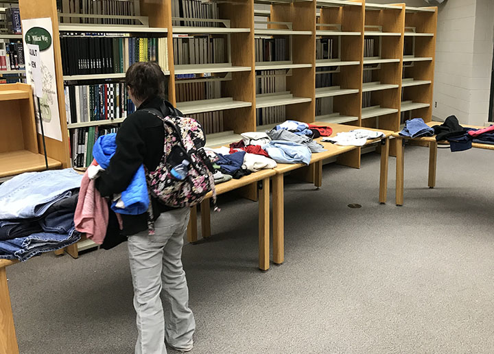 A parent chooses clothes from the Wildcat closet during parent teacher conferences.