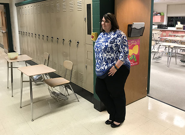 English teacher Sam Kukuk waits outside her classroom for her next parents.