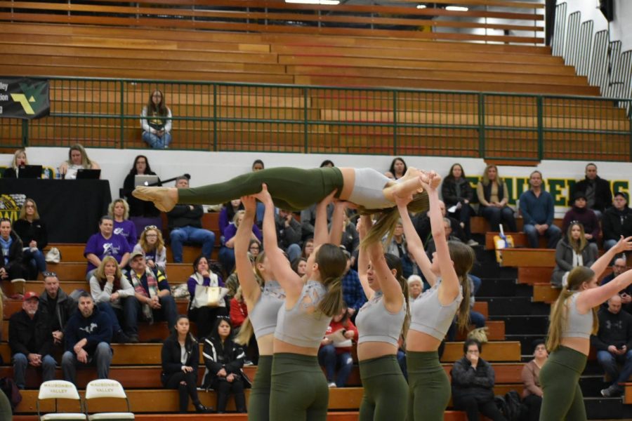 Sophomore Ella Majewski is lifted during the competition routine.