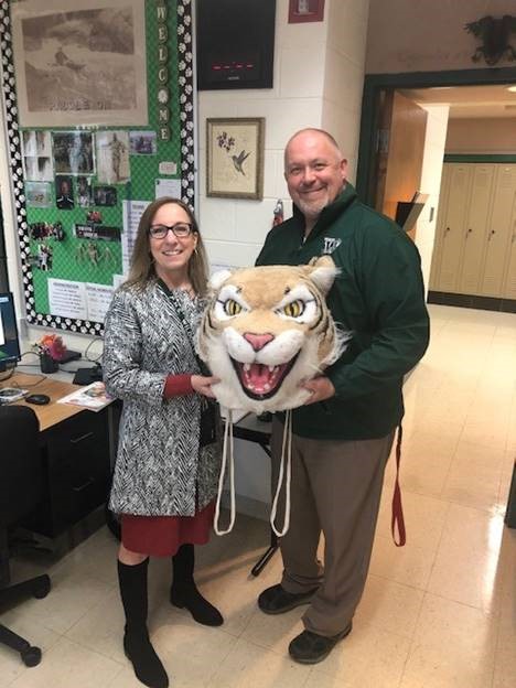 Mark Krusz, athletic director, passes the wildcat award to Deb Pohlmann, science teacher.