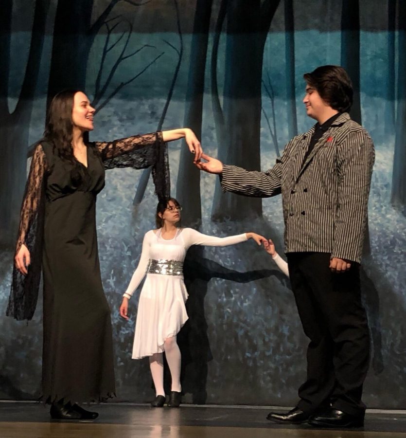 Sydney Schillinger, junior, and Joseph Sarabia, sophomore, share a tender moment on stage; they play Morticia and Gomez respectively. 
Photo by Paige Gieseke