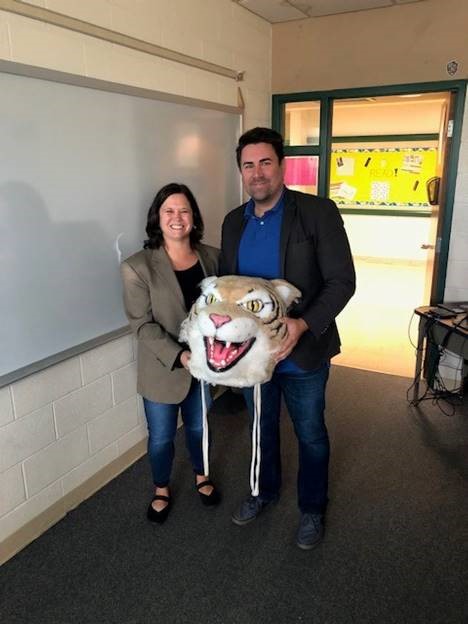 Jen Giorgetti, counselor, passes the Wildcat award to Adam Depew, English teacher.