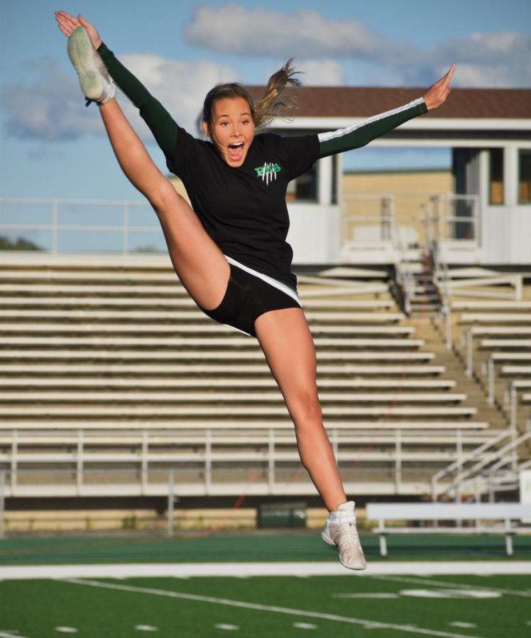 Brielle Kerzich, senior, flies above the stands during her cheer routine. 