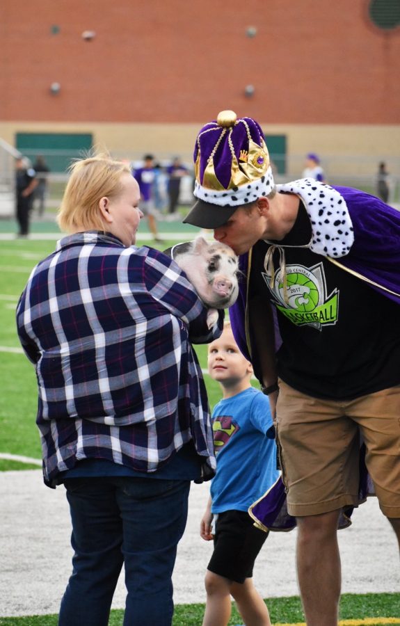 Gregg Bayer, PE teacher, kisses a pig after raising the most money in Kiss the Pig fundraiser that was held throughout homecoming week. 