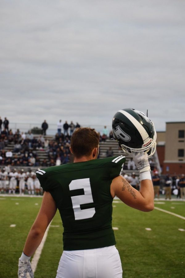 Kyle Gockman, junior, raises his helmet before first quarter.