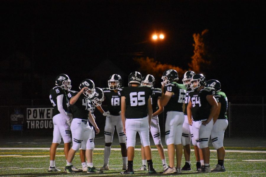 The varsity team huddles to discuss strategies during the fourth quarter.