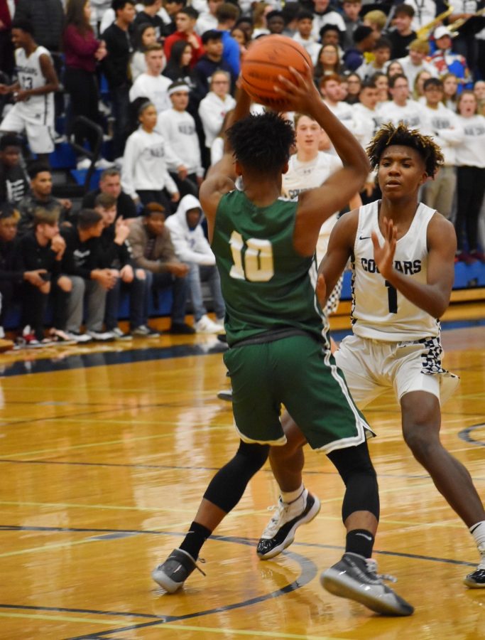 Tavari Johnson, senior, passes the ball over his opponent. 