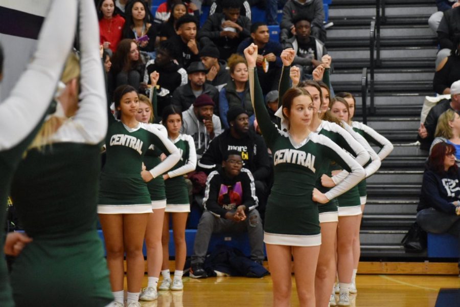 Anna Sherburne, senior, can be seen with the cheer team waiting as the basketball team is in timeout. 