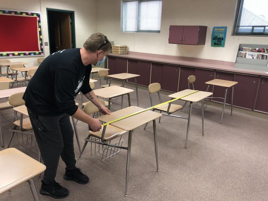 Ben Tuominen, deans assistant, measures desk spacing to follow proper social distancing guidelines.