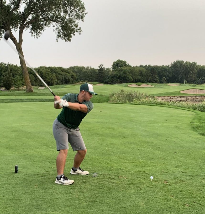 Senior Max Hunter swings the club as he smacks the ball down the fairway.