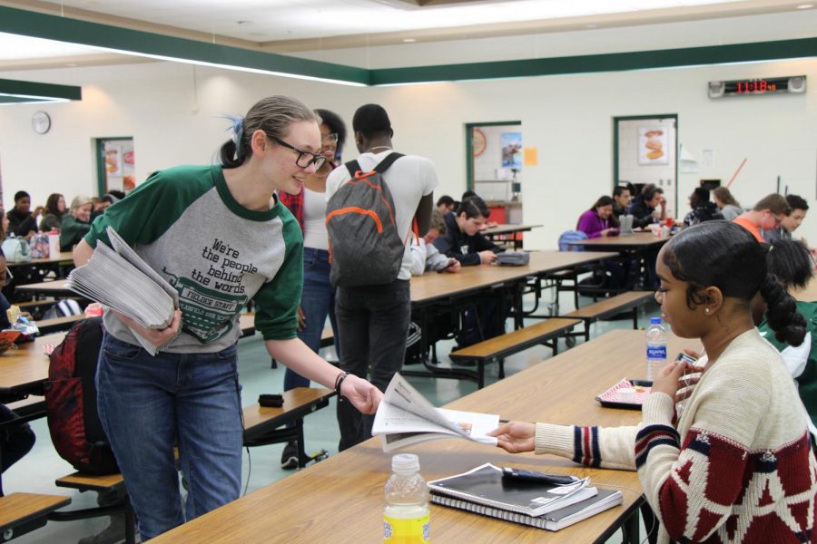 Raven Easterly, senior, passes out the student newspaper, the Fielder, during a lunch shift last year.