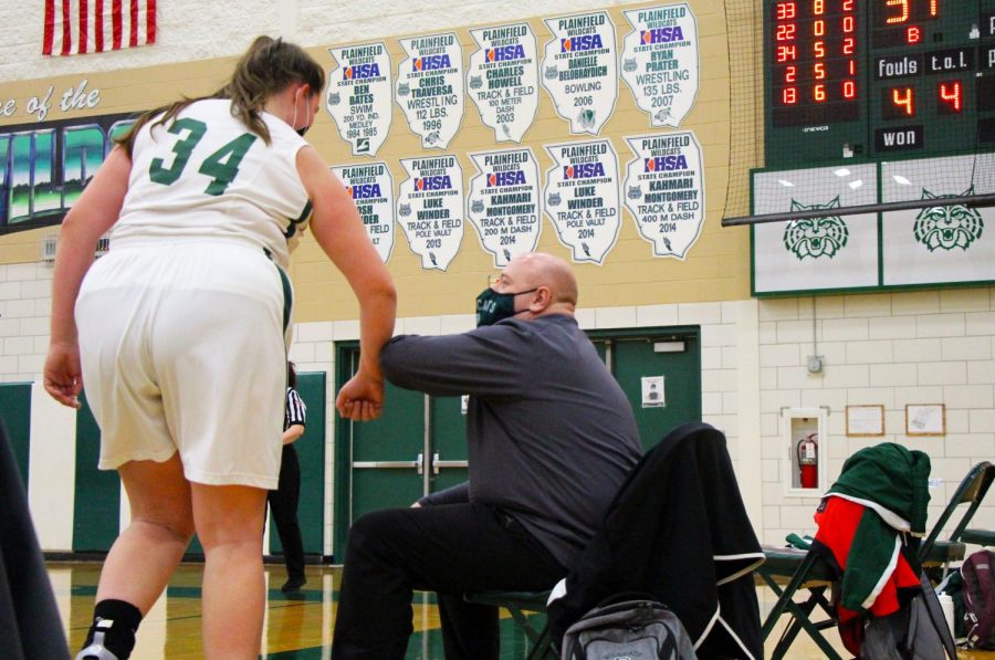 Assistant coach, Jason Held, elbow taps senior Georgia Jackson to commend her on her play in the first quarter. 