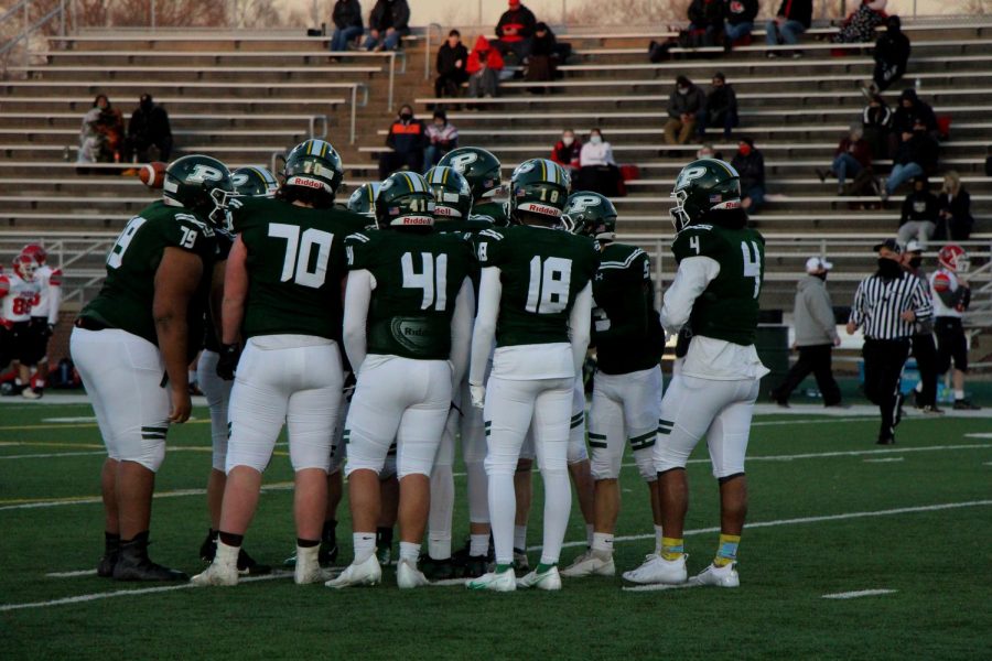 The players on the field huddle to discuss their next play.