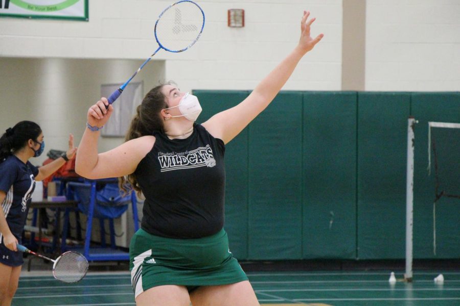 Senior, Georgia Jackson, lifts her racket to hit a clear shot.