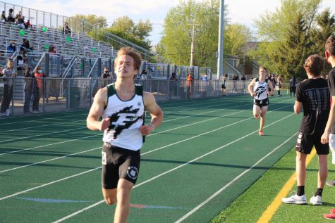 Michael  Forbear  and  Aaron  Wycoff,  juniors,  cross  the  finish  line  in  the  3200m event at the annual “Hunt Invitational.”