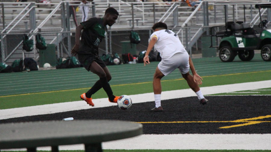 Moses+Mata%2C+senior%2C+dribbles+around+a++defender+in+the+Wildcats+2-2+tie+vs.+Plainfield+South+on+Sept.+14.