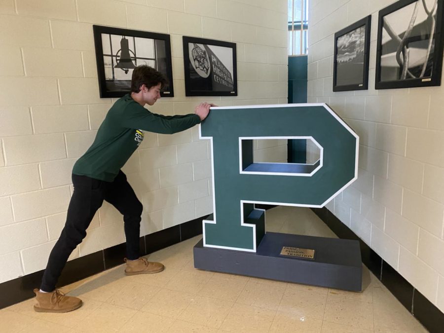 Logan Gieske posing next to his eagle scout project. 