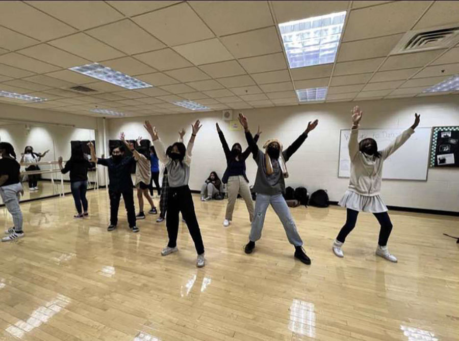 K-Pop club members practicing a dance routine from a K-Pop group in the dance room. 