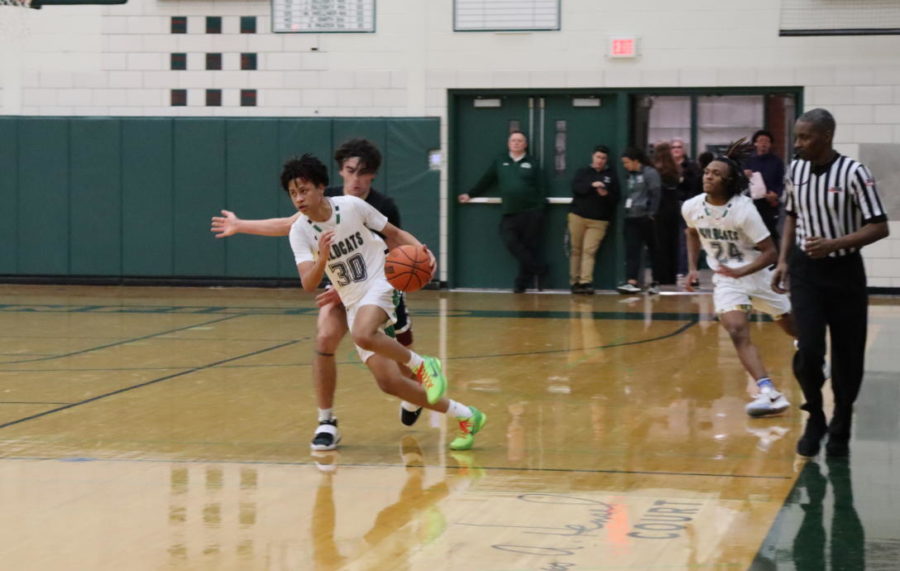 The boys varsity game vs. Plainfield North followed.  Tristan Saunders, sophomore, drives the ball down the court after an inbound.