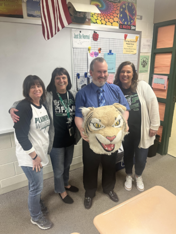 Val Zawistowski, Tracy Prah, and Cindy Osborn pass the Wildcat Award to Ted Arison, math teacher.