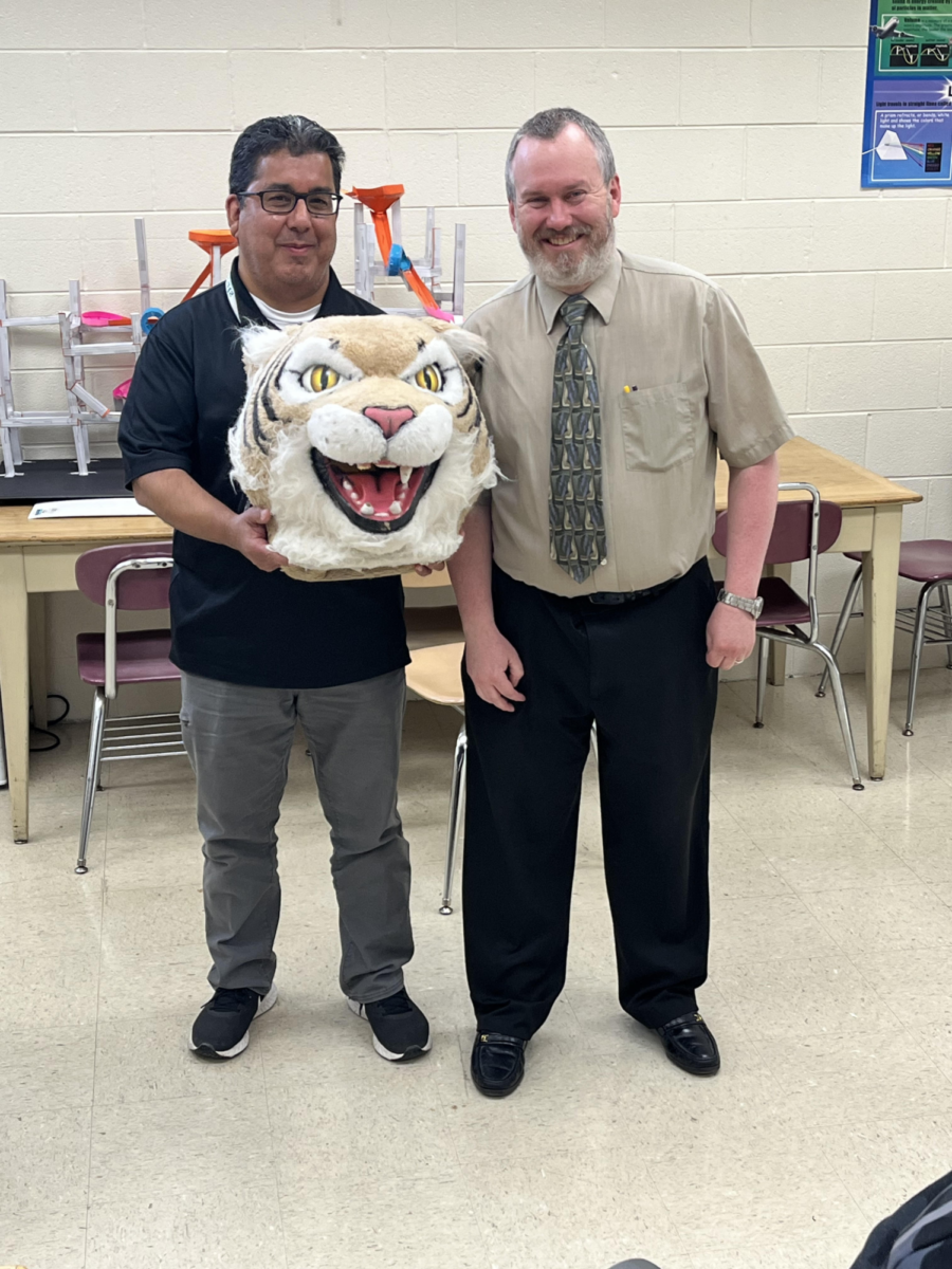 Ted Arison, math teacher, passes the Wildcat Award to Rich Gutierrez, RISE program instructor.