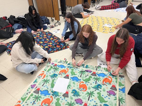 Students make blankets in Key Club after school on Nov. 29 to help other youth keep warm.
