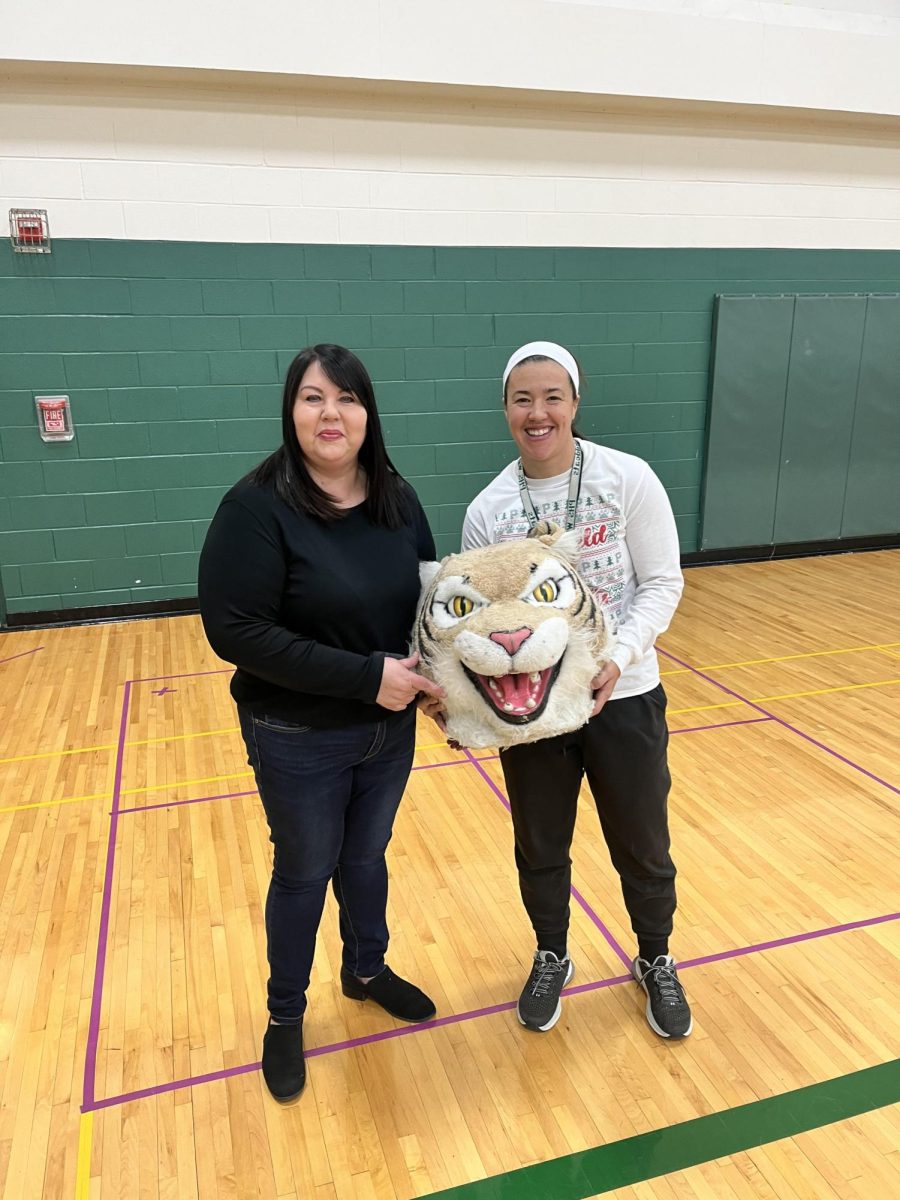 Colleen Cundari passes the Wildcat award to PE teacher Kate Welsh.