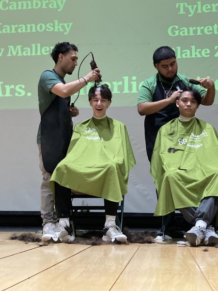Junior Aidan Petersen and senior Jayke Abarca get their heads shaved to support St. Baldrick’s. 