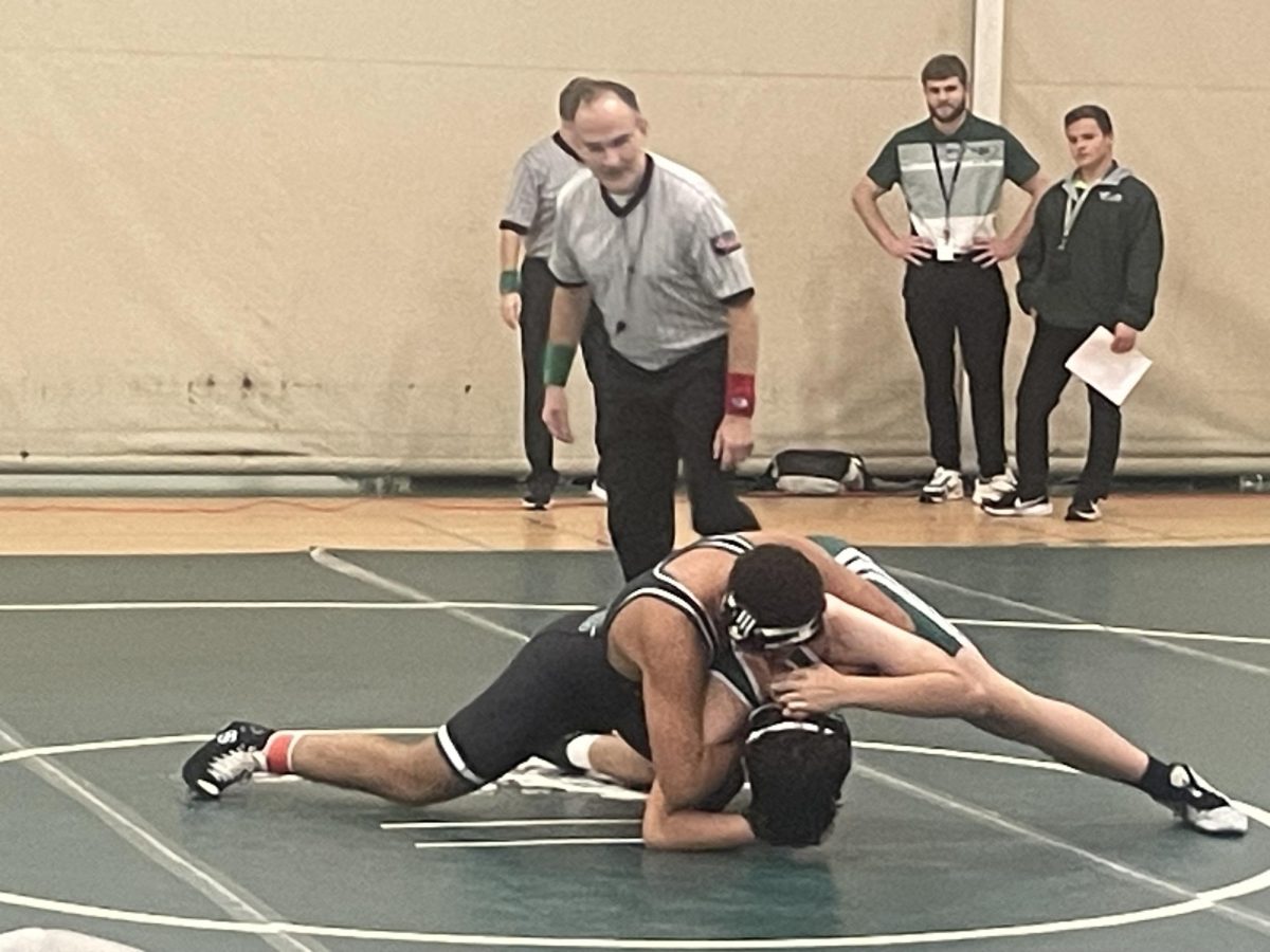 Sophomore, Ram Attaalla (top) pins freshman, Carter Taylor (bottom) for the win during green and white night on Nov. 21.